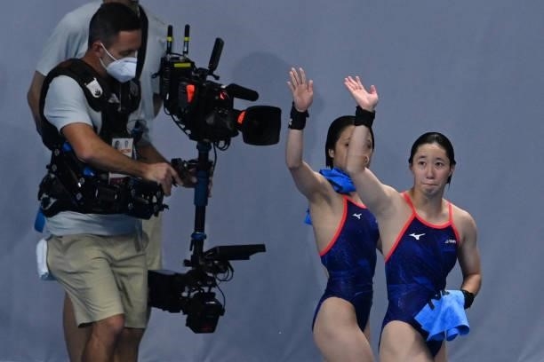 Japan's Matsuri Arai and Japan's Minami Itahashi wave as they leave after competing in the women's synchronised 10m platform diving final event...