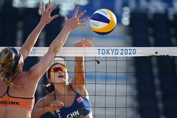 Netherlands' Madelein Meppelink tries to block a shot by China's Wang Xinxin during their women's preliminary beach volleyball pool B match between...