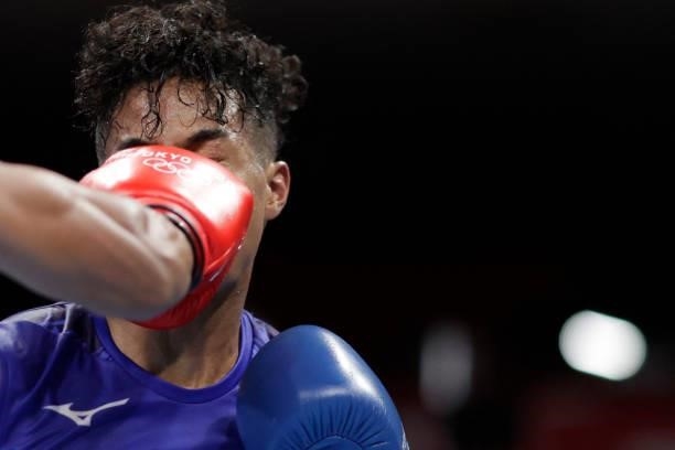 Japan's Sewonrets Quincy Mensah Okazawa takes a punch from Cuba's Roniel Iglesias during their men's welter preliminaries round of 16 boxing match...