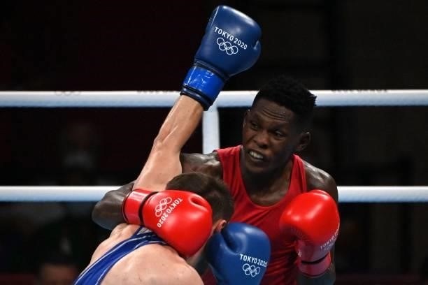Uganda's Shadiri Bwogi and Georgia's Eskerkhan Madiev fight during their men's welter preliminaries round of 16 boxing match during the Tokyo 2020...