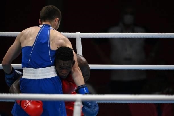 Uganda's Shadiri Bwogi and Georgia's Eskerkhan Madiev fight during their men's welter preliminaries round of 16 boxing match during the Tokyo 2020...