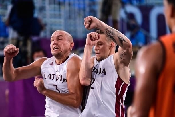 Latvia's Edgars Krumins and Latvia's Karlis Lasmanis celebrate after scoring a point during the men's first round 3x3 basketball match between Latvia...