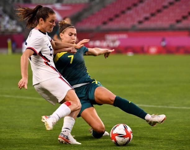 S defender Kelley O'Hara kicks the ball while Australia's defender Steph Catley attempts to block during the Tokyo 2020 Olympic Games women's group G...