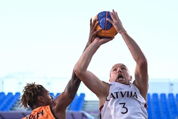 Netherlands' Jessey Voorn fights for the ball with Latvia's Edgars Krumins during the men's first round 3x3 basketball match between Latvia and...