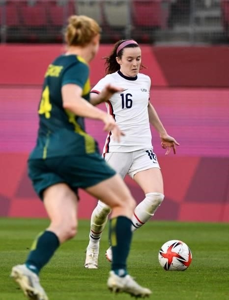 S midfielder Rose Lavelle dribbles the ball beside Australia's defender Clare Polkinghorne during the Tokyo 2020 Olympic Games women's group G first...