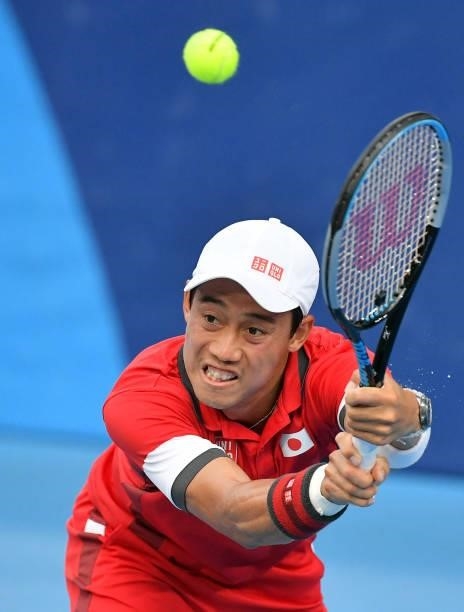 Japan's Kei Nishikori returns the ball to USA's Marcos Giron during their Tokyo 2020 Olympic Games men's singles second round tennis match at the...