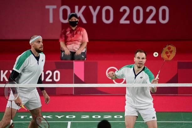 Russia's Ivan Sozonov hits a shot next to Russia's Vladimir Ivanov in their men's doubles badminton group stage match against Nigeria's Godwin Olofua...