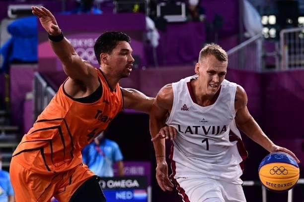 Netherlands' Arvin Slagter fights for the ball with Latvia's Nauris Miezis during the men's first round 3x3 basketball match between Latvia and...