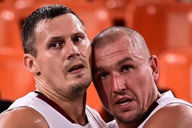 Latvia's Agnis Cavars and Latvia's Edgars Krumins celebrate after wiining at the end of the men's first round 3x3 basketball match between Latvia and...