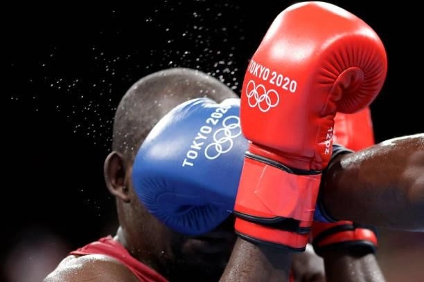 Kenya's Elly Ajowi Ochola and Cuba's Julio La Cruz shake fight during their men's heavy preliminaries round of 16 boxing match during the Tokyo 2020...