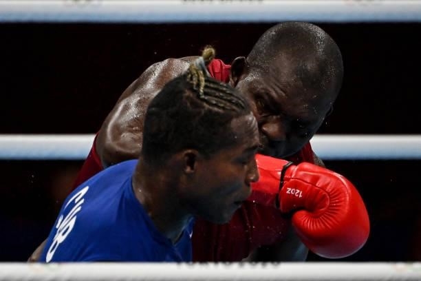 Kenya's Elly Ajowi Ochola and Cuba's Julio La Cruz fight during their men's heavy preliminaries round of 16 boxing match during the Tokyo 2020...