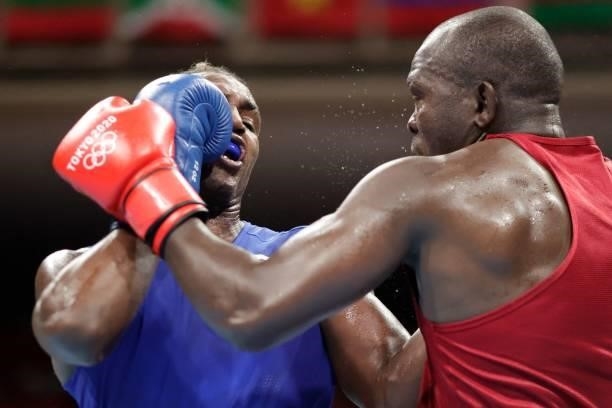 Kenya's Elly Ajowi Ochola and Cuba's Julio La Cruz shake fight during their men's heavy preliminaries round of 16 boxing match during the Tokyo 2020...