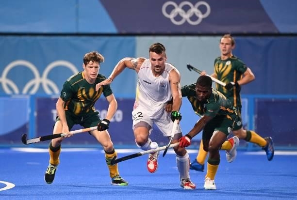 Belgium's Simon Pierre Gougnard is marked by players of South Africa during their men's pool B match of the Tokyo 2020 Olympic Games field hockey...