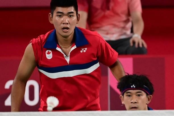 Canada's Nyl Yakura and Canada's Jason Ho-Shue watch the shuttlecock in their men's doubles badminton group stage match against Malaysia's Aaron Chia...