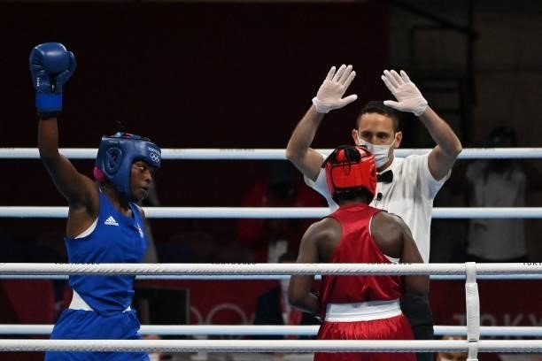 The referee gestures to Kenya's Elizabeth Akinyi after she lost by KO her fight against Mozambique's Acinda Helena Panguana during their women's...