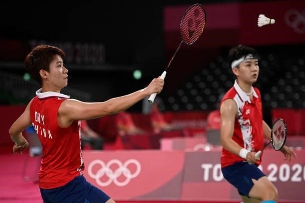 China's Du Yue hits a shot next to China's Li Yinhui in their women's doubles badminton group stage match against South Korea's Lee So-hee and South...