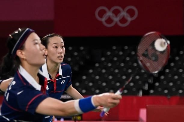South Korea's Lee So-hee hits a shot next to South Korea's Shin Seung-chan in their women's doubles badminton group stage match against China's Li...