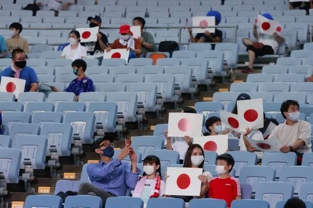 Supporters hold Japanese flags during the Tokyo 2020 Olympic Games women's group E first round football match between Chile and Japan at the Miyagi...