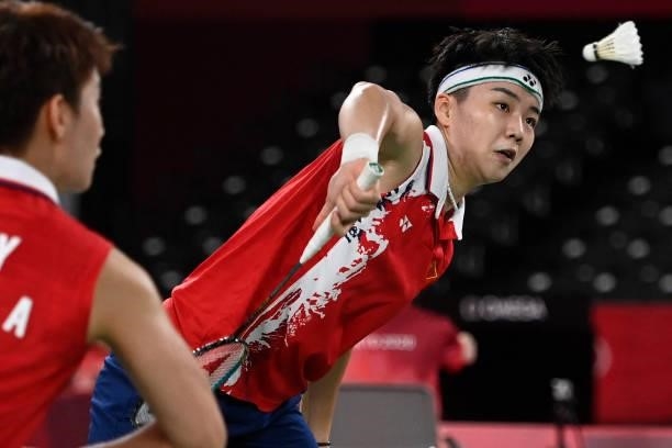 China's Li Yinhui hits a shot next to China's Du Yue in their women's doubles badminton group stage match against South Korea's Lee So-hee and South...