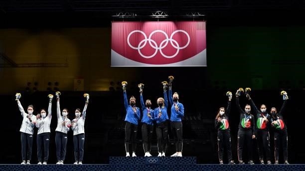 Gold medallist Estonia's team fencers celebrates on podium with South Korea's team fencers silver medallist and Italy's team fencers bronze medallist...