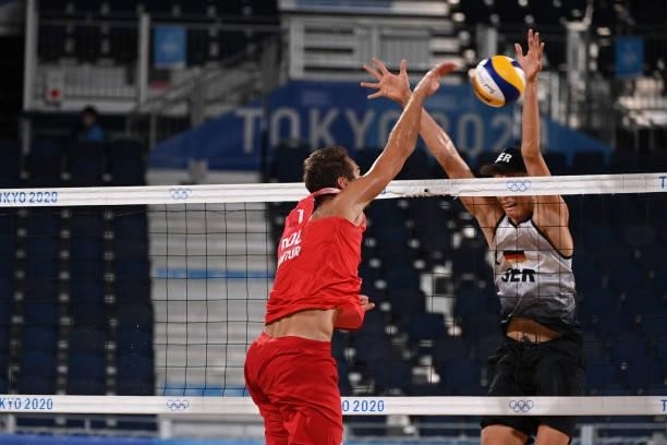 Germany's Julius Thole tries to block Poland's Piotr Kantor in their men's preliminary beach volleyball pool F match between Germany and Poland...