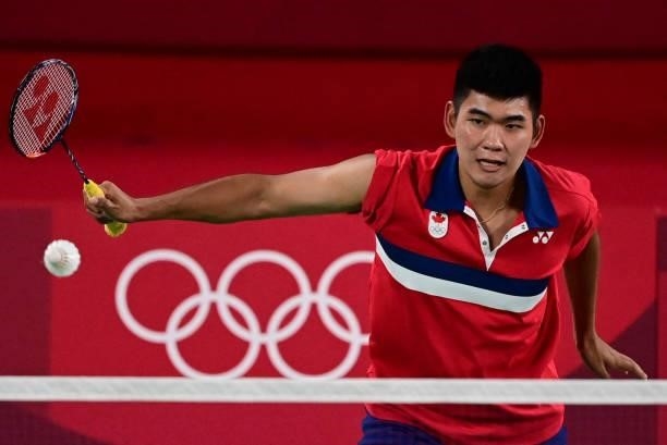 Canada's Jason Ho-Shue hits a shot in his men's doubles badminton group stage match with Canada's Nyl Yakura against Malaysia's Aaron Chia and...