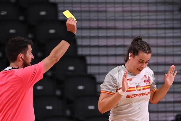 Spain's pivot Ainhoa Hernandez Serrador is shown a yellow card by referee during the women's preliminary round group B handball match between France...