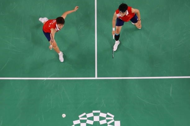 China's Du Yue hits a shot next to China's Li Yinhui in their women's doubles badminton group stage match against South Korea's Lee So-hee and South...