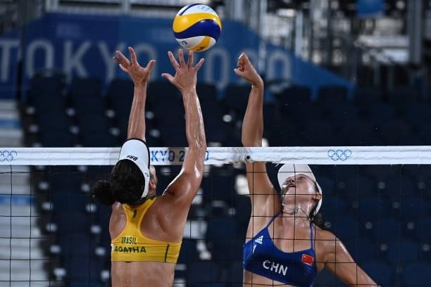 Brazil's Agatha Bednarczuk tries to block China's Wang Fan in their women's preliminary beach volleyball pool C match between Brazil and China during...