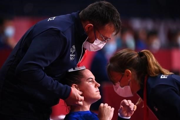France's centre back Alexandra Lacrabere is treated by medical staff during the women's preliminary round group B handball match between France and...