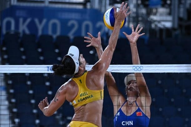 China's Wang Fan tries to block Brazil's Agatha Bednarczuk in their women's preliminary beach volleyball pool C match between Brazil and China during...
