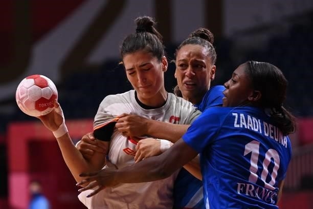 Spain's left back Lara Gonzalez Ortega is challenged by France's pivot Beatrice Edwige and France's centre back Grace Zaadi Deuna during the women's...