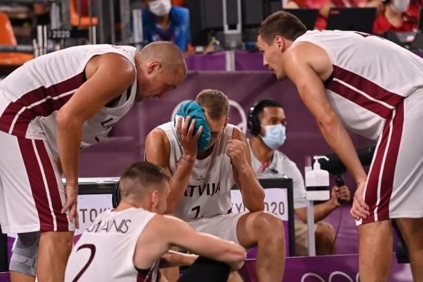 Latvia's team-players speak together during the men's quarter final 3x3 basketball match between Latvia and Japan at the Aomi Urban Sports Park in...
