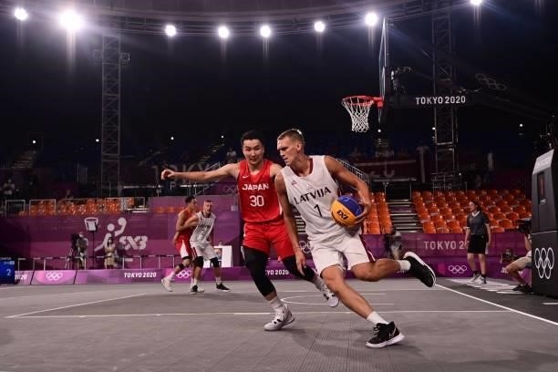 Latvia's Nauris Miezis runs with the ball past Japan's Keisei Tominaga during the men's quarter final 3x3 basketball match between Latvia and Japan...