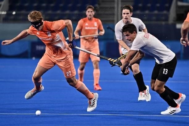 Netherlands' Jip Janssen and Canada's Brendan Guraliuk vie for the ball during their men's pool B match of the Tokyo 2020 Olympic Games field hockey...