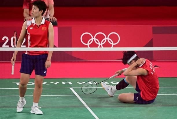 China's Li Yinhui sits on the court in her women's doubles badminton group stage match with China's Du Yue against South Korea's Lee So-hee and South...