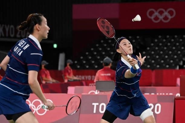 South Korea's Shin Seung-chan hits a shot next to South Korea's Lee So-hee in their women's doubles badminton group stage match against China's Li...