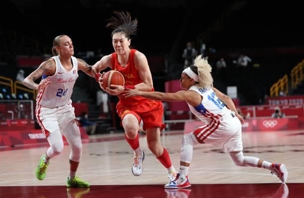 China's Sun Mengran goes to the basket past Puerto Rico's Jazmon Gwathmey and Dayshalee Salamanin the women's preliminary round group C basketball...