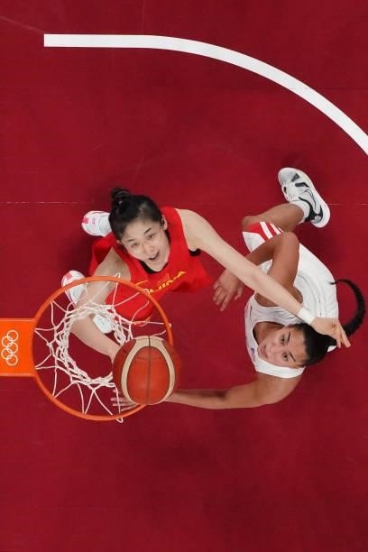 Puerto Rico's Tayra Melendez and China's Wang Siyu look at the basket in the women's preliminary round group C basketball match between China and...