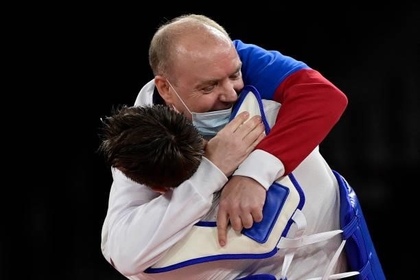 Russia's Vladislav Larin celebrates with his coach after winning the taekwondo men's +80kg gold medal bout during the Tokyo 2020 Olympic Games at the...