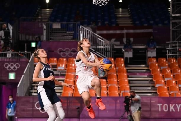 Japan's Mio Shinozaki jumps to score past France's Ana Maria Filip during the women's quarter final 3x3 basketball match between Japan and France at...