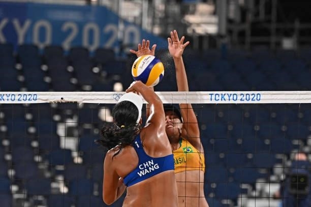 Brazil's Agatha Bednarczuk tries to block a shot by China's Wang Fan during their women's preliminary beach volleyball pool C match between Brazil...