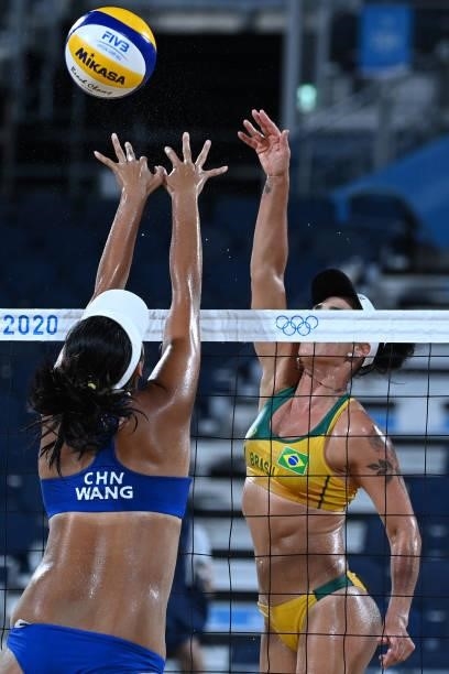 China's Wang Fan tries to block a shot by Brazil's Agatha Bednarczuk during their women's preliminary beach volleyball pool C match between Brazil...