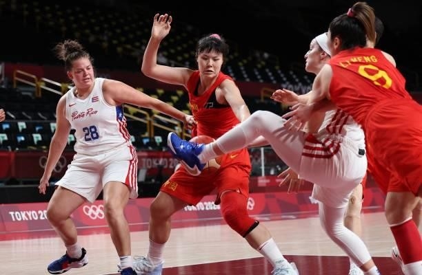 Puerto Rico's Sabrina Lozada-Cabbage and China's Sun Mengran fight for the ball in the women's preliminary round group C basketball match between...