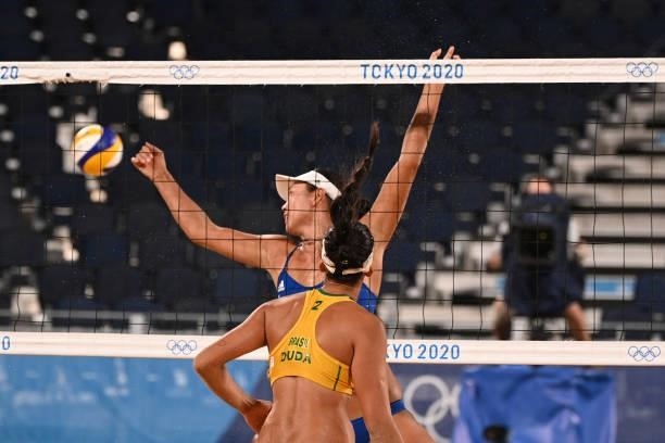 China's Wang Fan and Brazil's Eduarda Santos Lisboa watch the ball during their women's preliminary beach volleyball pool C match between Brazil and...