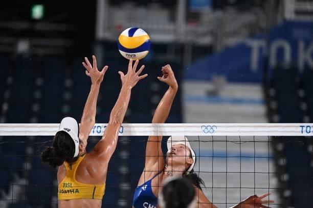 Brazil's Agatha Bednarczuk tries to block a shot by China's Wang Fan during their women's preliminary beach volleyball pool C match between Brazil...