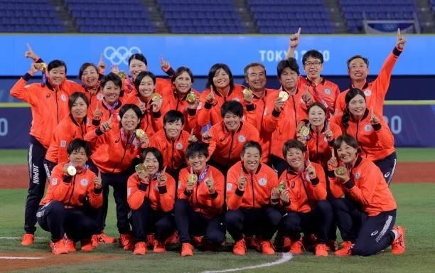Gold medal winner, Japan's softball players show off their medal for a family photo after the medal ceremony for the softball competition in the...