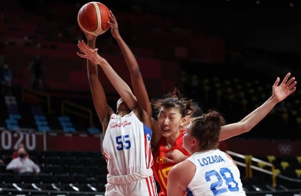 Puerto Rico's Jackie Benitez and China's Han Xu jump for a rebound in the women's preliminary round group C basketball match between China and Puerto...