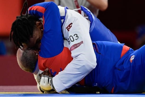 Cuba's Rafael Yunier Alba Castillo celebrates his his coach after winning the taekwondo men's +80kg bronze medal B bout during the Tokyo 2020 Olympic...
