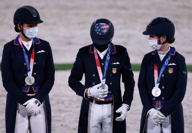 Silver medalist Adrienne Lyle, Steffen Peters and Sabine Schut-Kery of the US celebrate on the podium of the dressage grand prix special team...